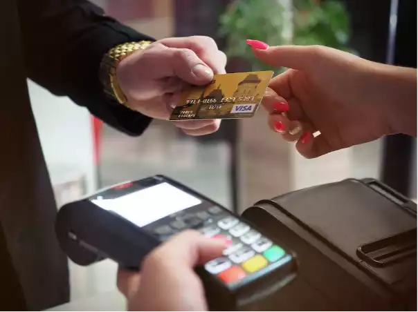 A person paying with a credit cardDescription automatically generated with low confidence